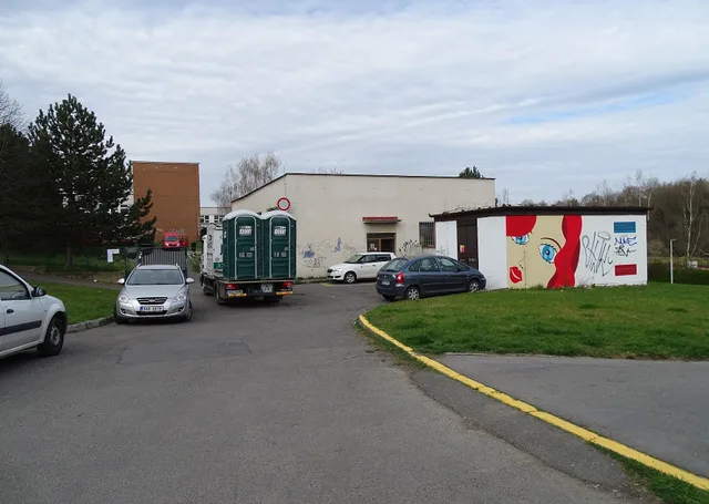 Prague - Modřany , Czech Republic . Rakovského street, a truck with portable toilets, a distribution electrical station with murals. Disaster surge operations for portable restroom fleets